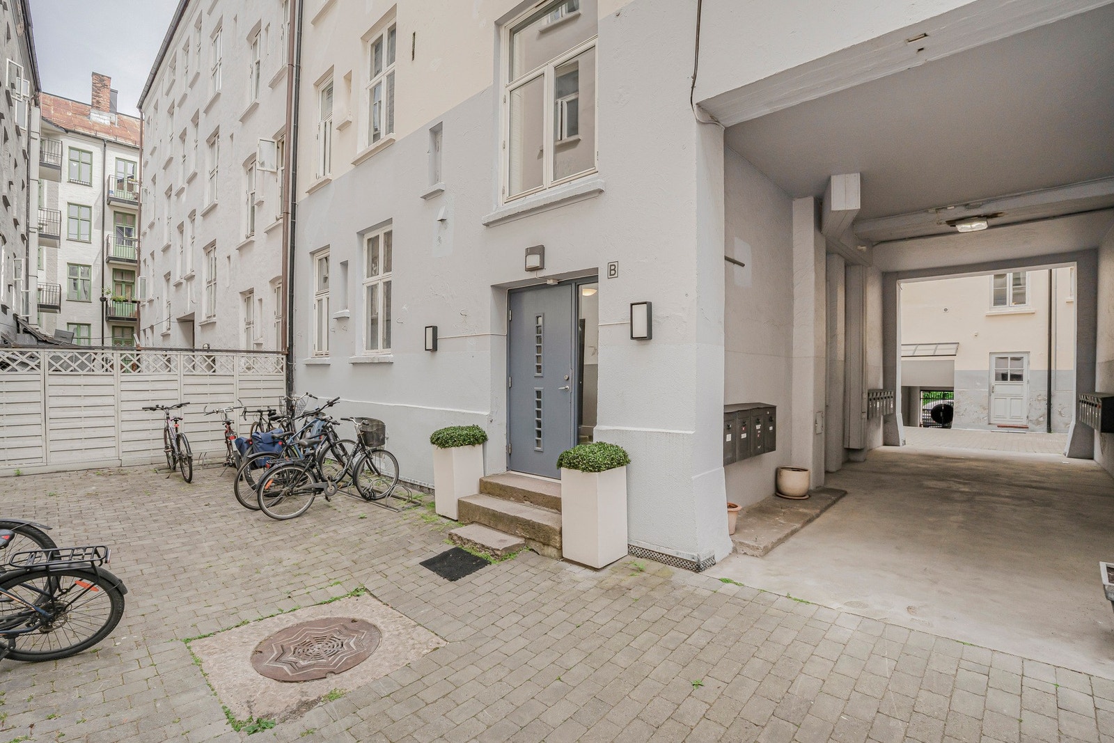 Hyggelig og skjermet bakgård med sykkelparkering, inngang til oppgangen og portrom med adkomst til gaten. Galleribilde