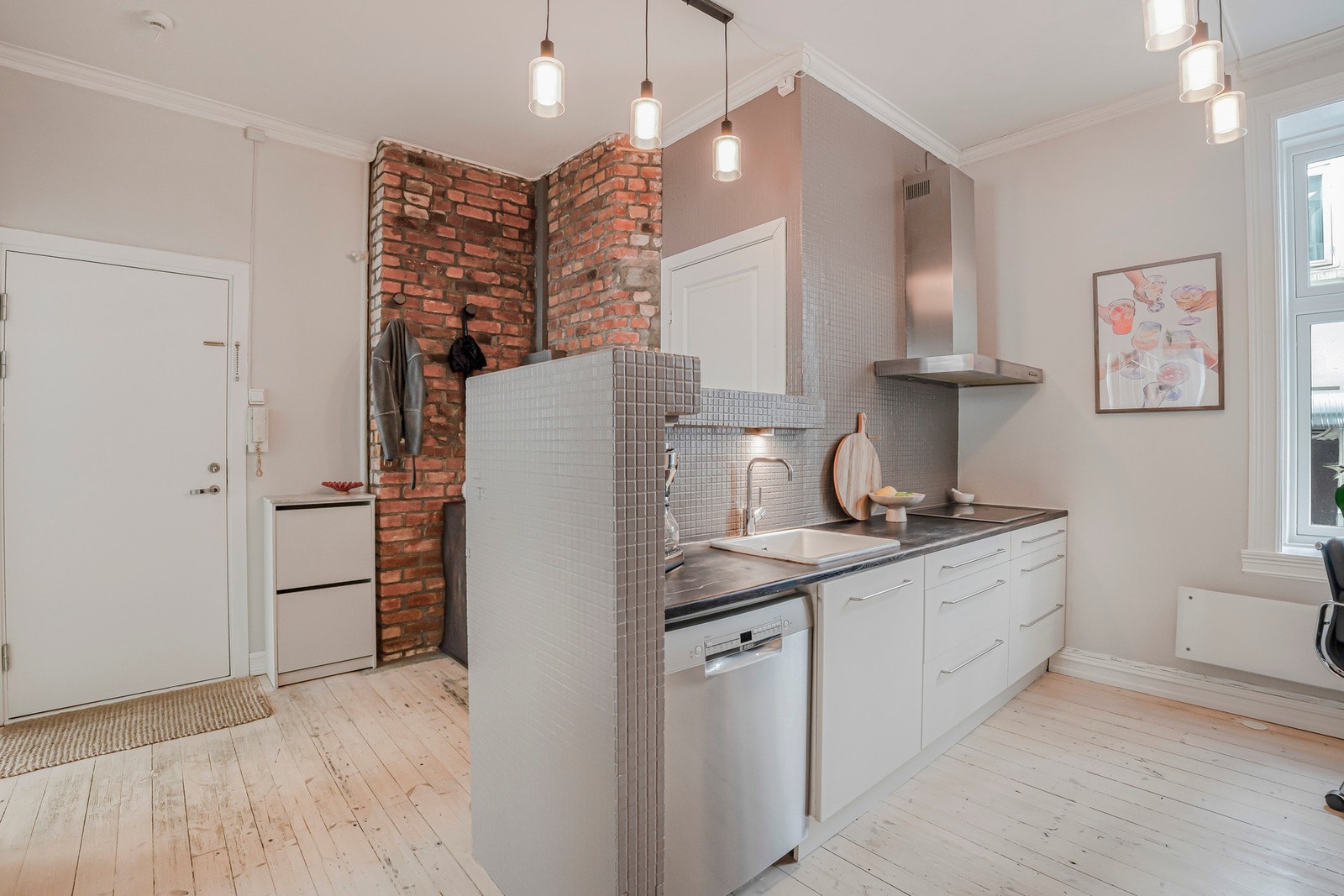 Kjøkkenet har en moderne innredning med slette, beige/kalk fronter og mørk benkeplate som gir et stilrent uttrykk. Galleribilde