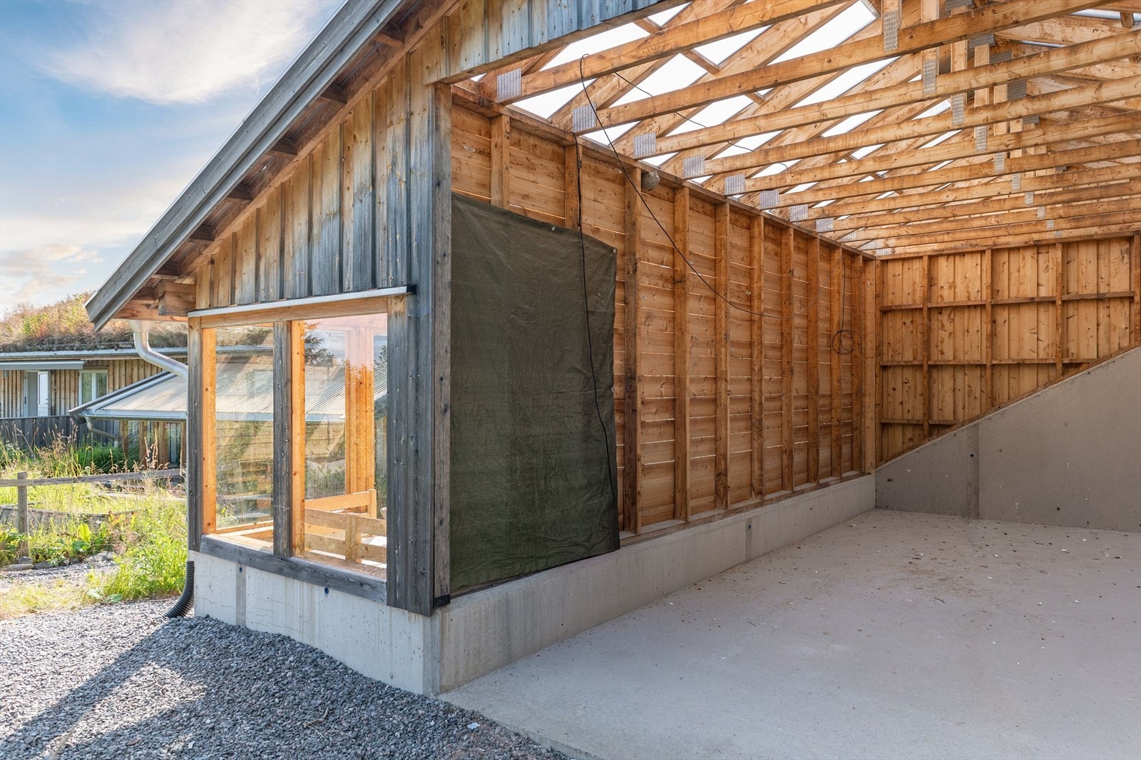 Carport med ekstra god takhøyde som gir fleksible bruksmuligheter og god plass til både kjøretøy, utstyr og lagring. Foto: Husfoto/TW Galleribilde