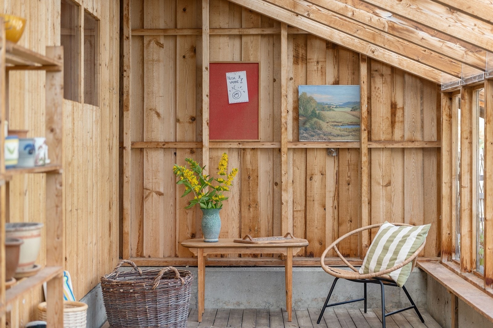 Ta en pause blant tomatplanter og blomster - drivhuset byr på en lun sitteplass med utsikt til egen avling. Foto: Husfoto/TW Galleribilde