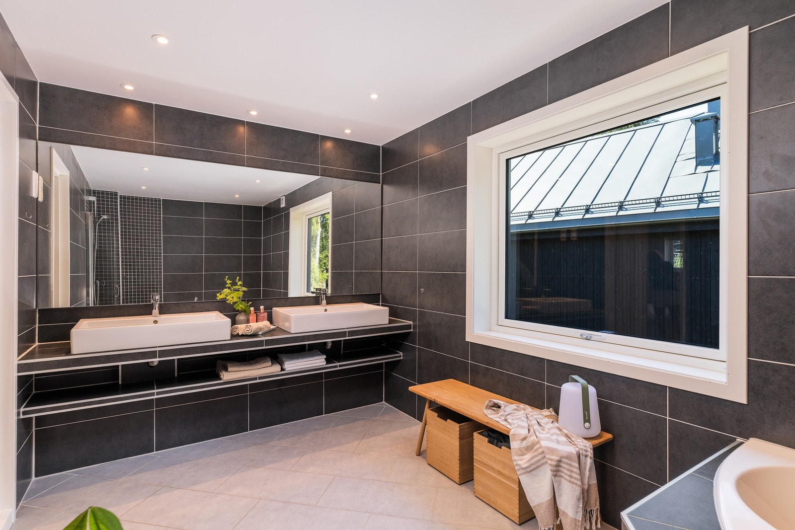 Badet er innredet med en praktisk dobbel servant med flislagt benkeplate og speil over. Galleribilde