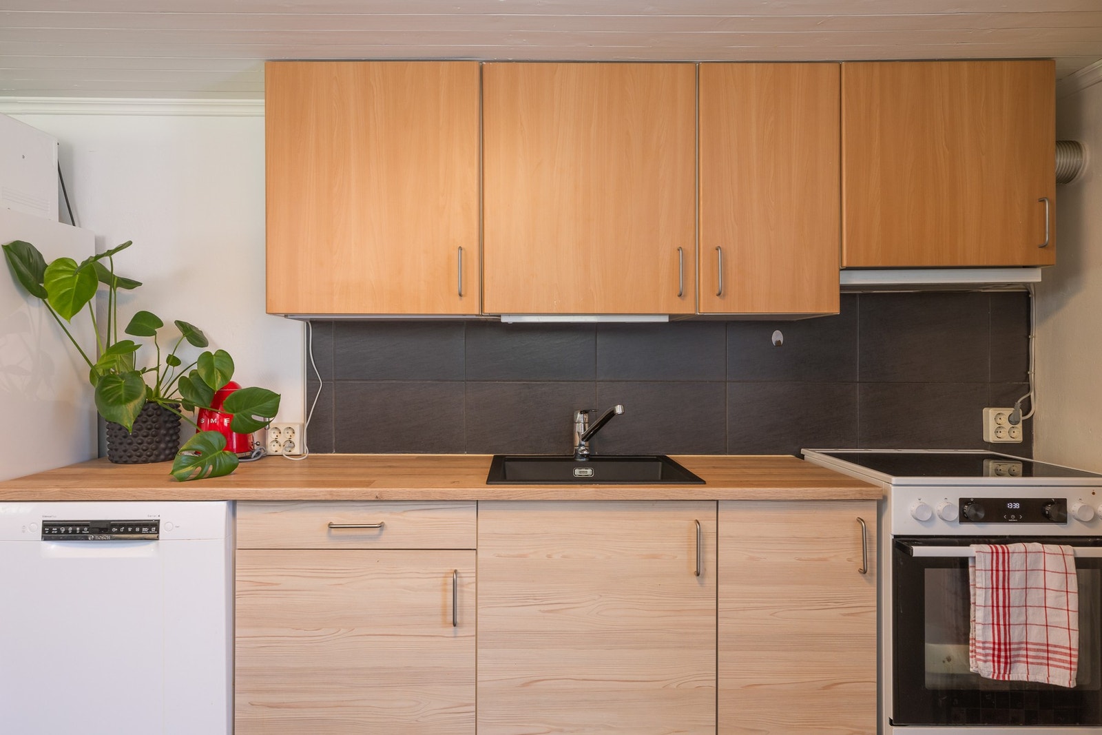 Kjøkkenet har innredning med glatte fronter og laminat benkeplate, samt. ventilator. Galleribilde