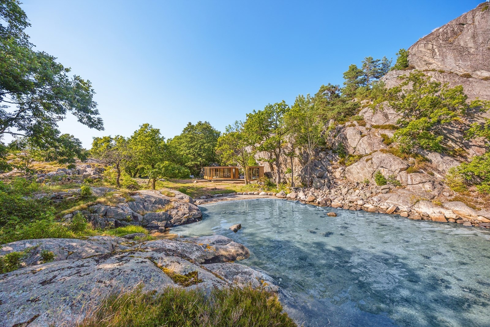Hytten ligger innerst i bukten - nesten i ett med omgivelsene. Galleribilde