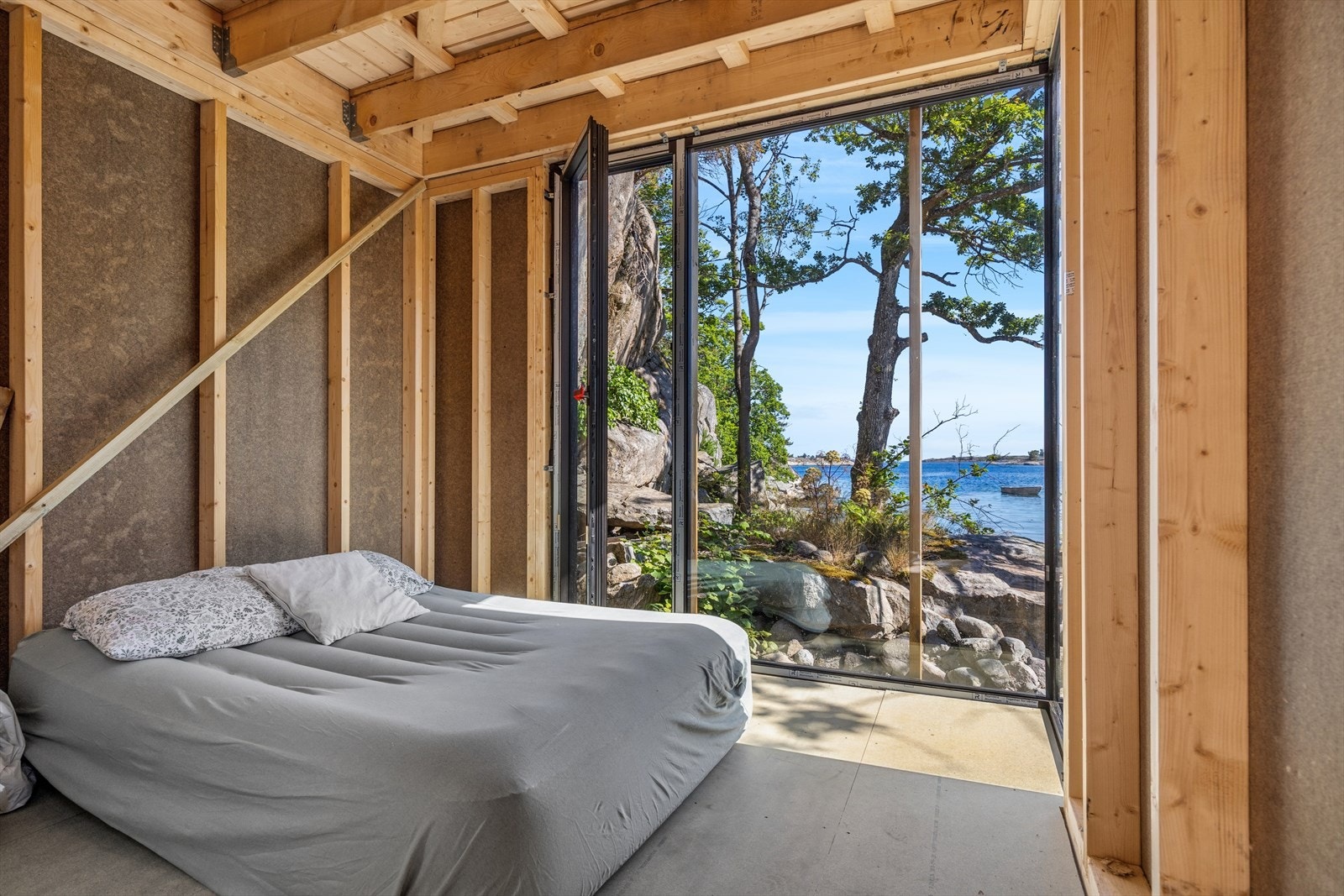 Soverom 1 i annekset. Hyttens fineste soverom. Her våkner du i strandkanten med fantastisk utsikt hele døgnet. Galleribilde