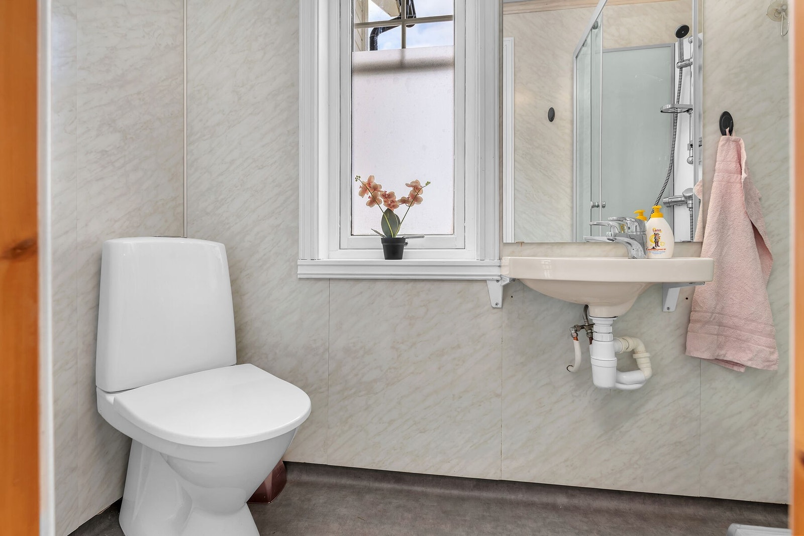 Badet har våtromsplater på veggene og vinylbelegg på gulvet. Galleribilde