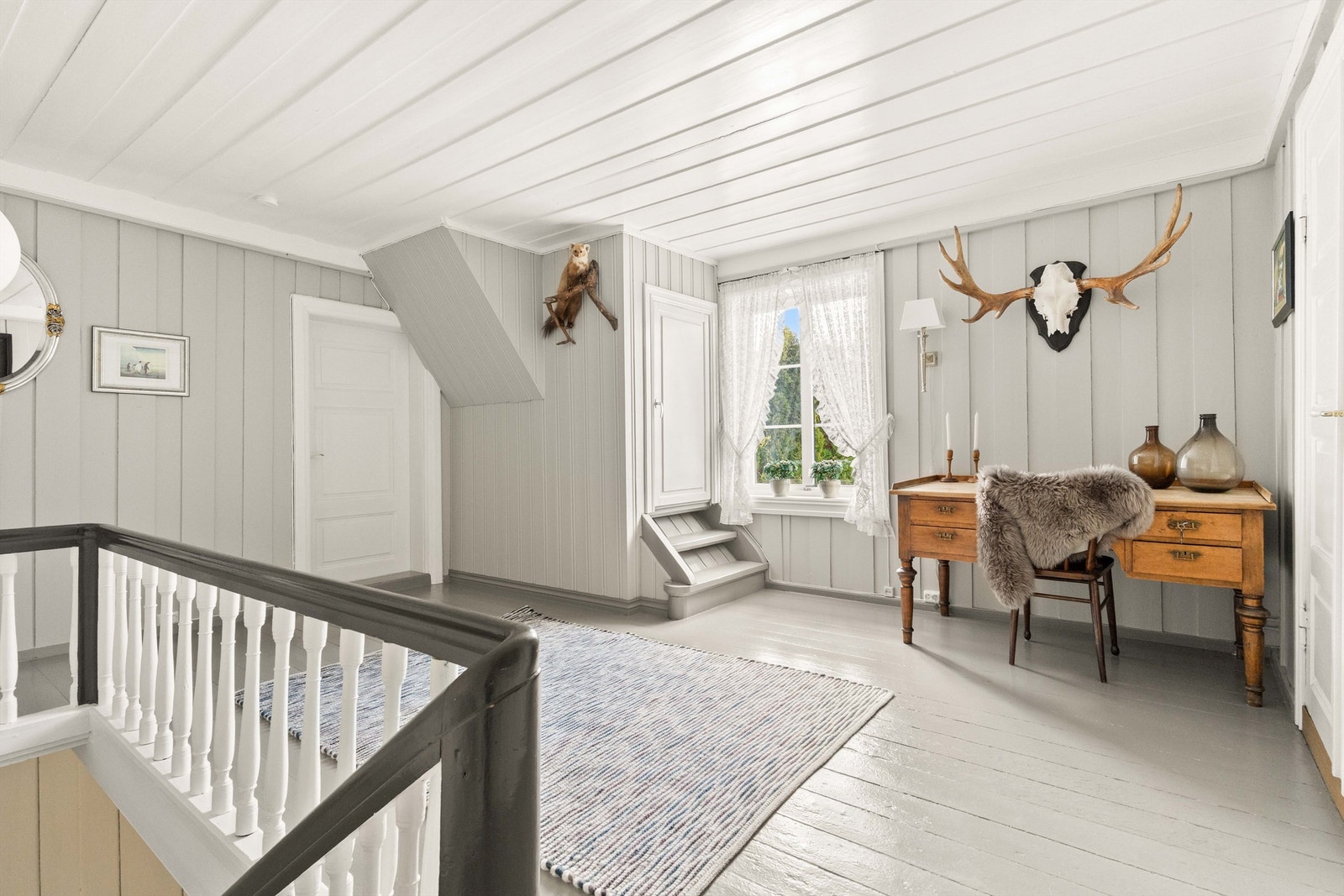 Ankomst til andre etasje. Gangen har malt tregulv og leder videre til soverommene og verandaen. Galleribilde