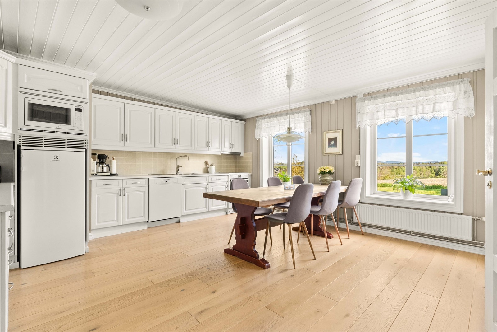 Stort spisekjøkken med parkettgulv og god plass til langbord. Kjøleskap, oppvaskmaskin og komfyr medfølger. Galleribilde