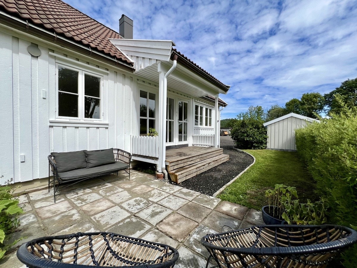 Koselig uteområde med gressplen, platting og veranda i Inngangsparti Galleribilde
