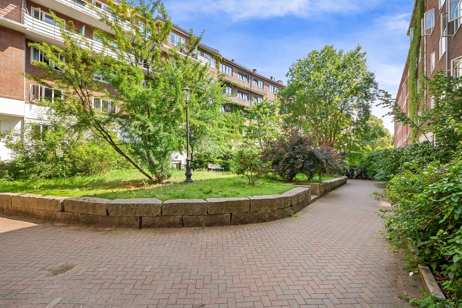 ellesområder opparbeidet med steinlagte internveier, sittebenker, sykkelparkering, plenareal, prydbusker og diverse beplantning. Galleribilde