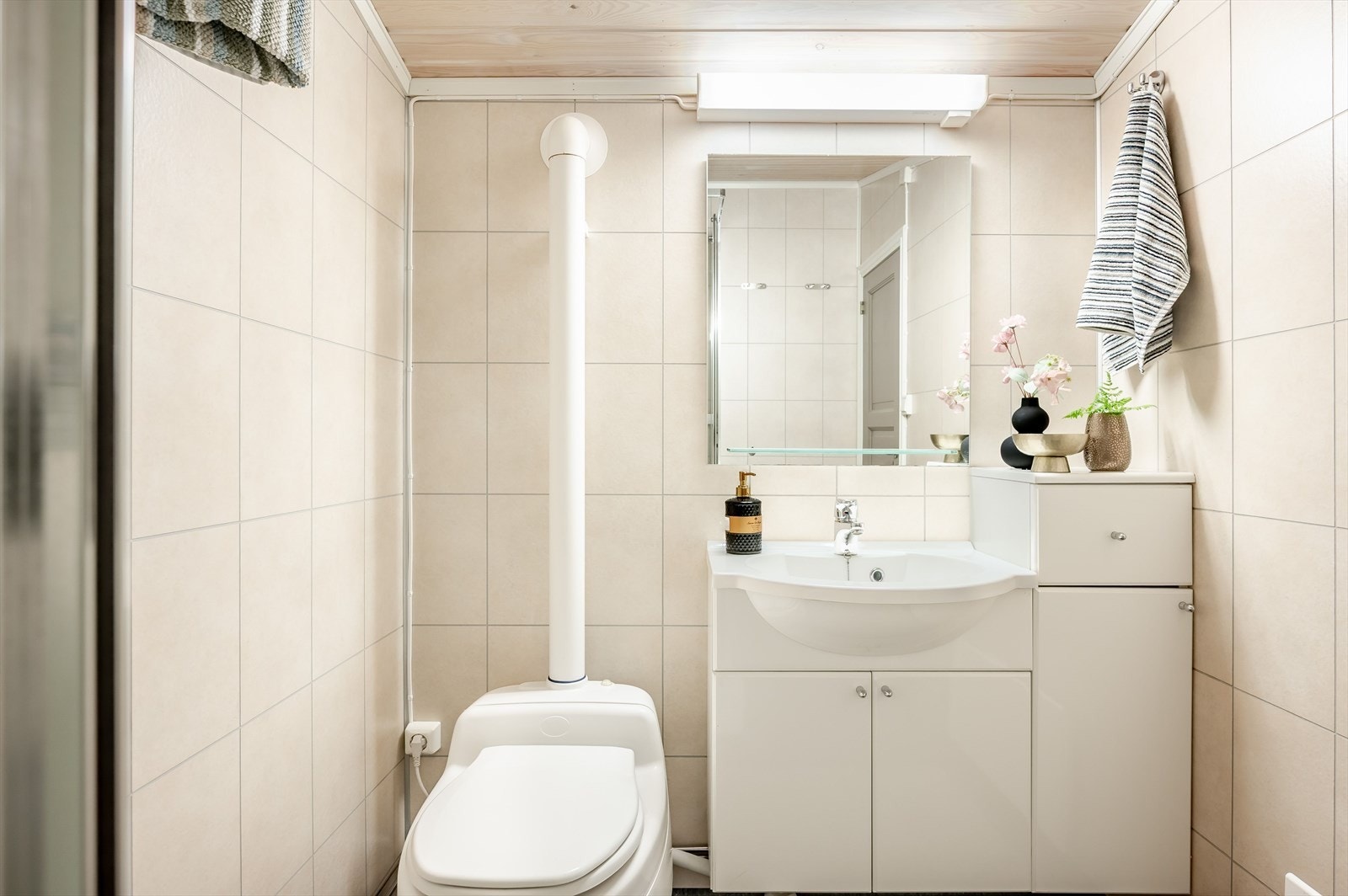 Baderommet er utstyrt med lys baderomsinnredning med servant, dusjkabinett og hyttedo type Separett (med bøtte for tømming og det våte går ut via avløp). Galleribilde
