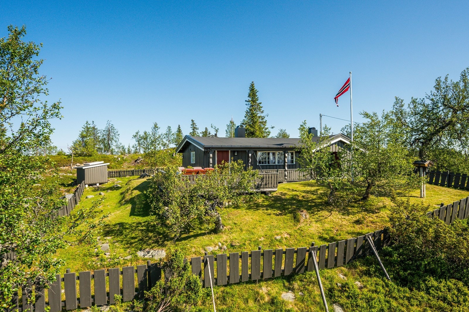 Utenfor hytta er det en stor og solrik terrasse, samt en fin inngjerdet hage med port. Galleribilde