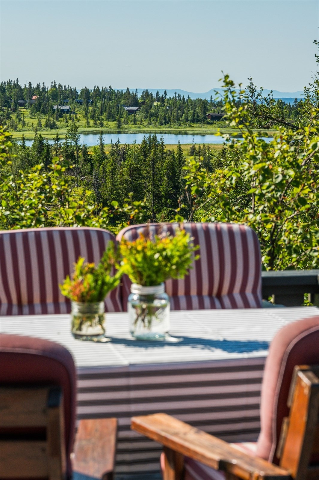 Her kan bare nyte stillheten og den fine utsikten over vakker natur med vannspeil og fjelltopper i horisonten. Galleribilde