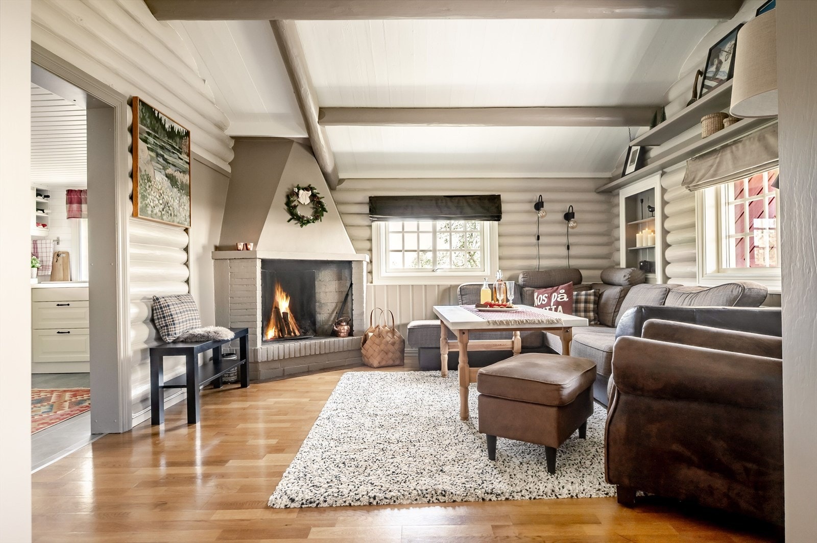 Fra kjøkkenet kommer du videre inn til en hyggelig peisestue. I hjørnet er det en koselig murt åpen peis som bidrar til ekstra hygge. Galleribilde