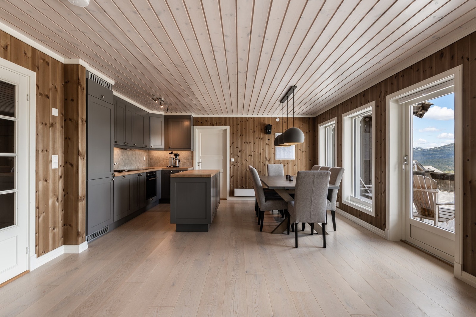 Kjøkken og spiseplass med flott utsikt og utgang til terrassen. Døra bortenfor kjøkkenet leder inn til soveromsavdelingen. Galleribilde