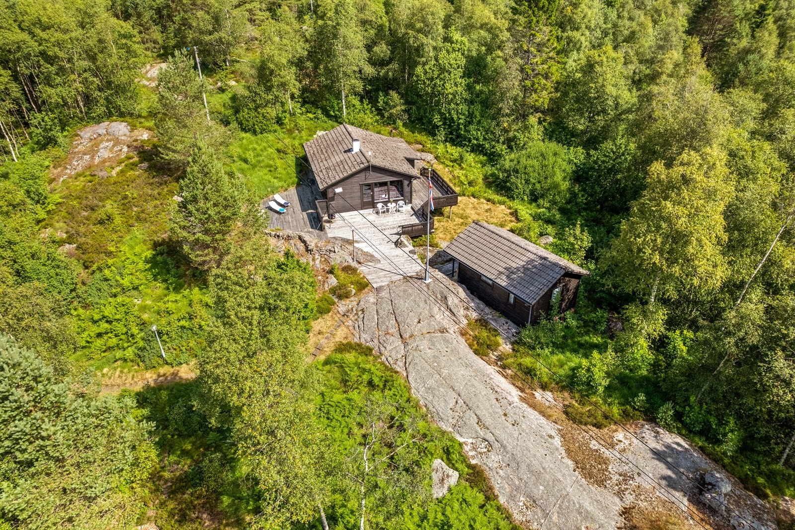 Eiendommen ligger usjenert til i et skogområde med spredt fritidsbebyggelse. Galleribilde