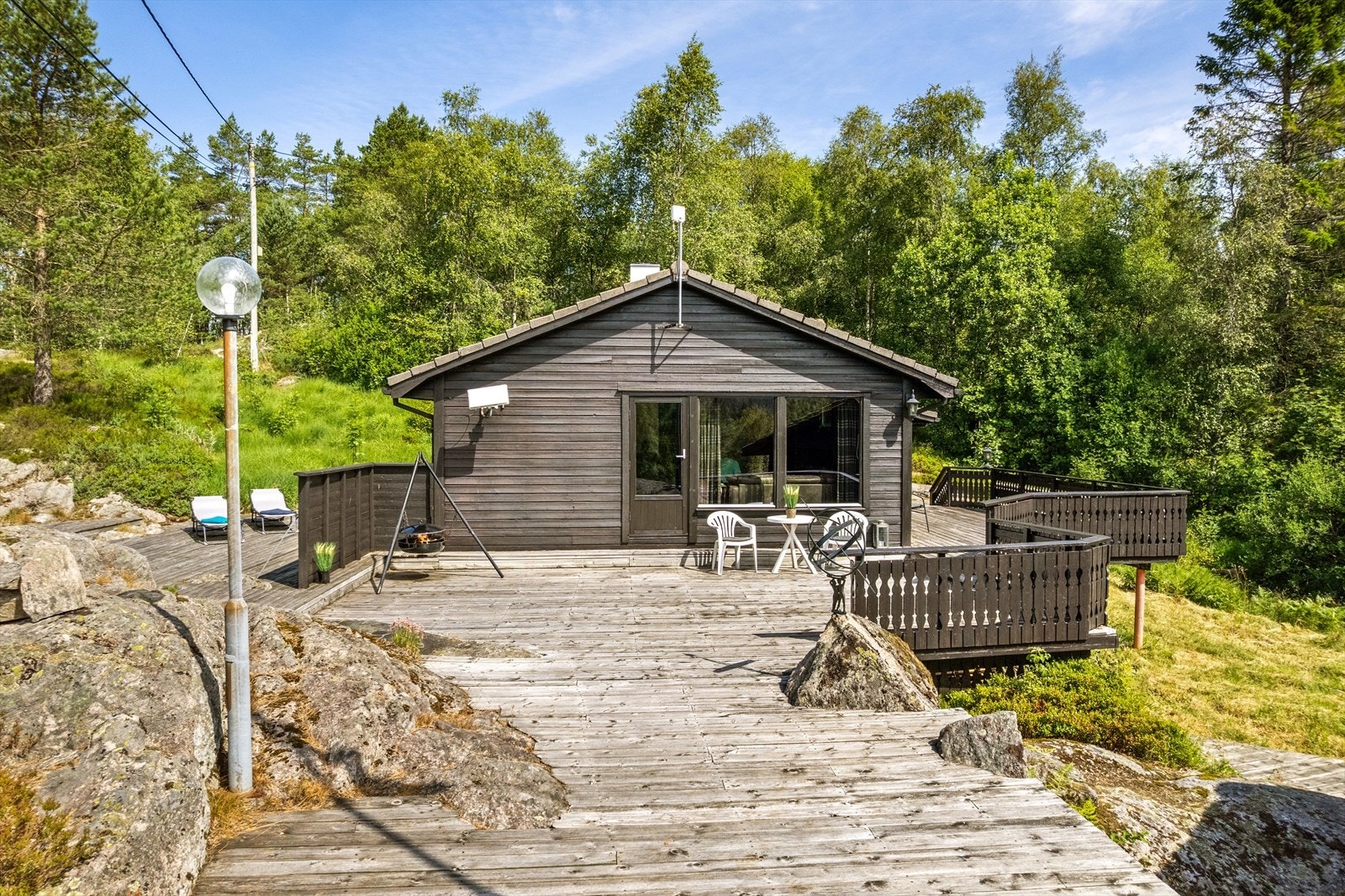 Hytta er bygget på pilarer i skrånende terreng. Galleribilde