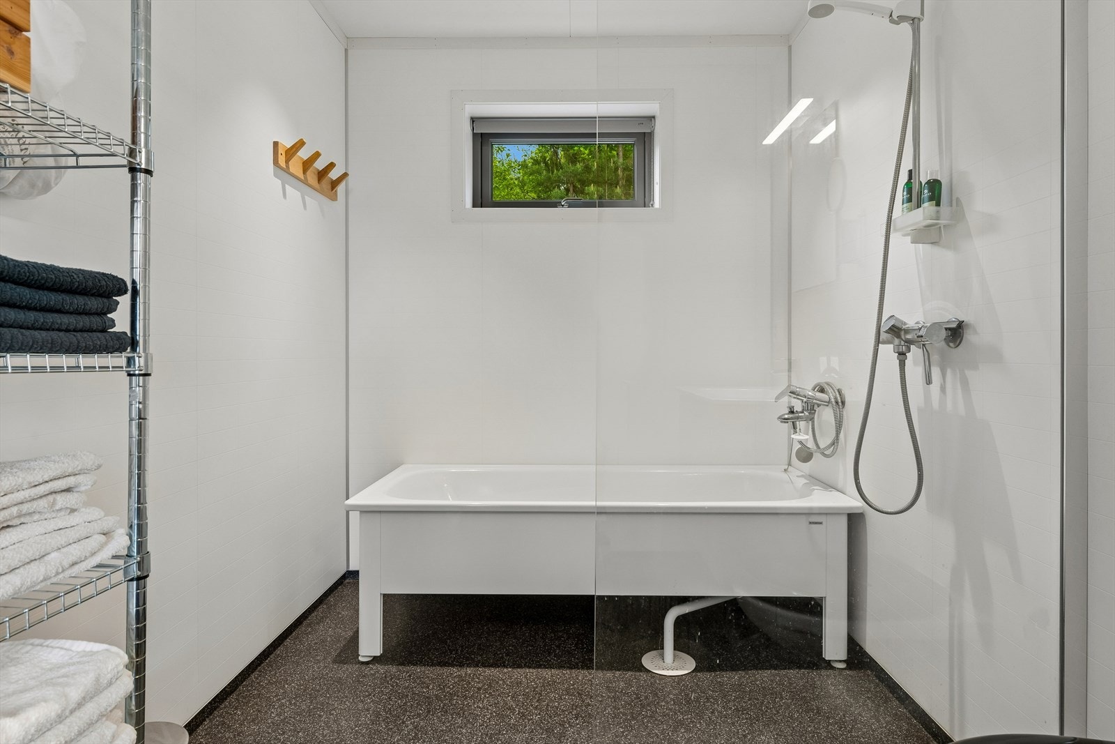 Baderomsplater på veggene og dusjvegg i glass gir et funksjonelt og lettstelt bad. Galleribilde