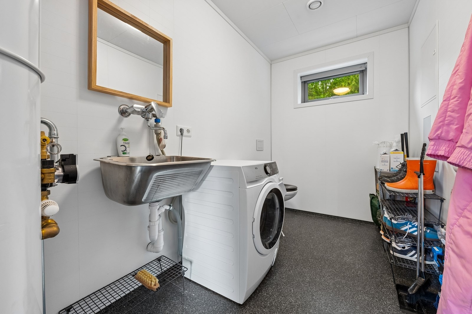 Praktisk vaskerom med toalett, vegghengt skyllekar og opplegg for vaskemaskin. Galleribilde