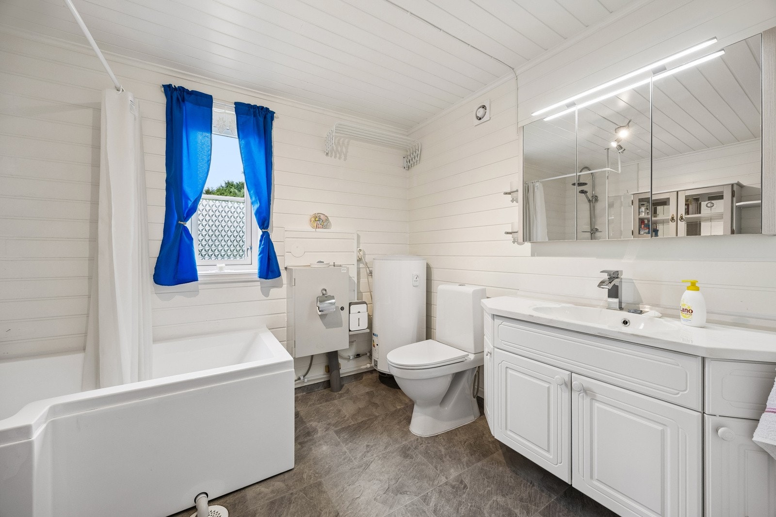 Bad/wc/vaskerom med gulvvarme, wc og badekar med dusjløsning. Badet har vindu og elektrisk styrt vifte