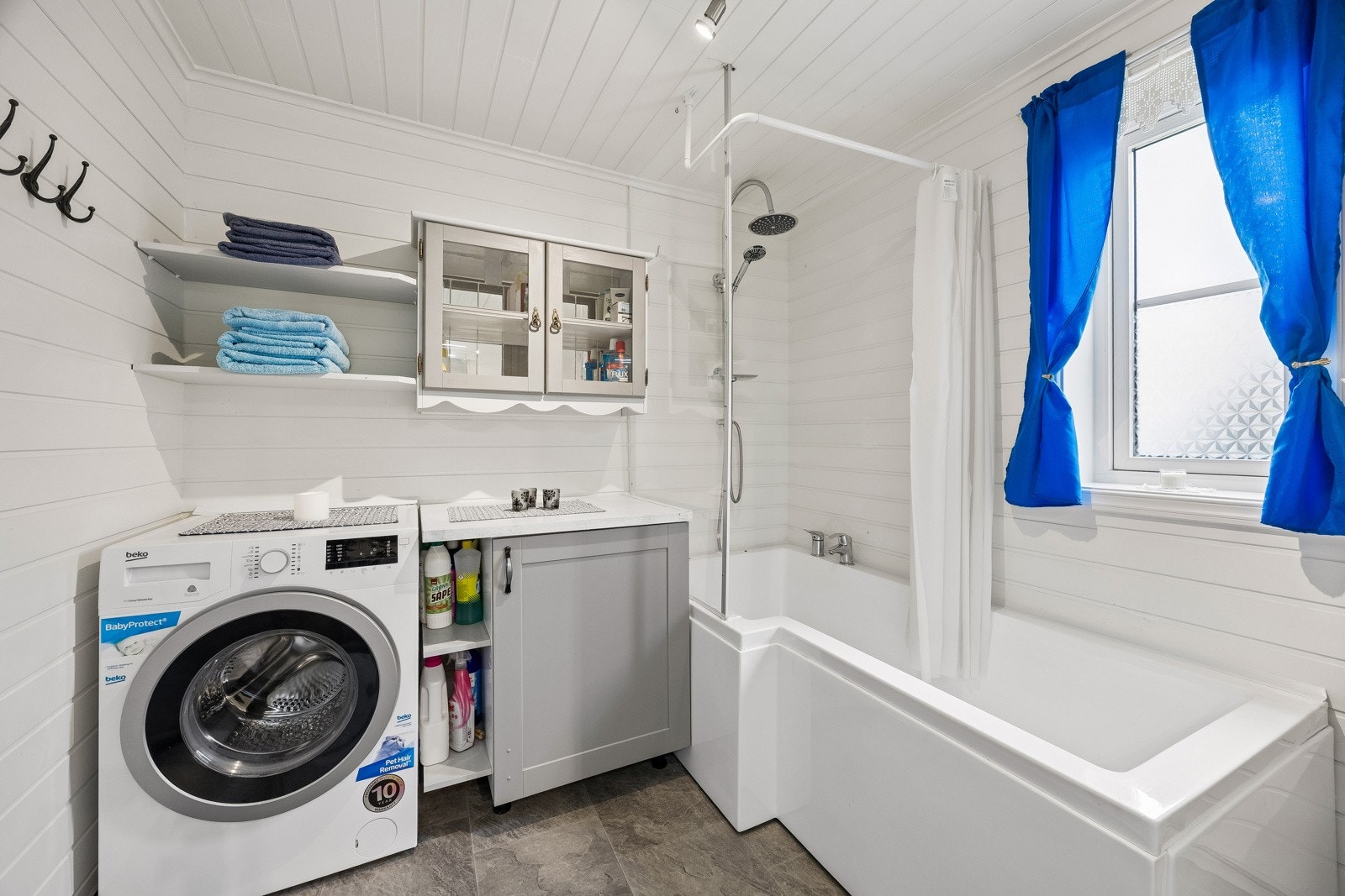 Videre har badet opplegg for vaskemaskin og ekstra oppbevaringsplass i hyller og skap.