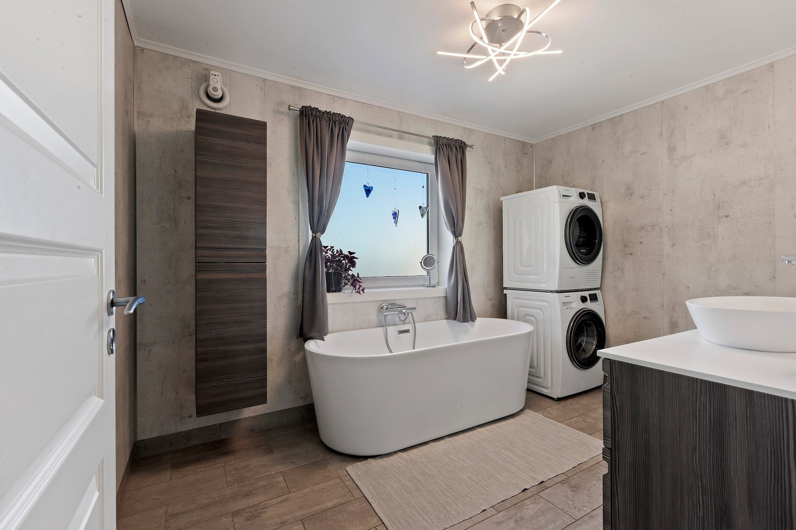 Badet er stilrent innredet og utstyrt med et lekkert badekar som innbyr til avslappende stunder, opplegg for vaskemaskin. Galleribilde