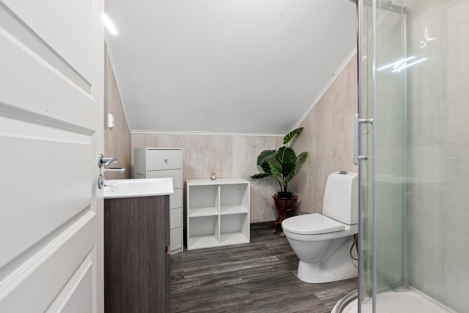 Badet har innredning med nedfelt servant og skuffer under, speil med lys over, dusjkabinett og toalett. Galleribilde