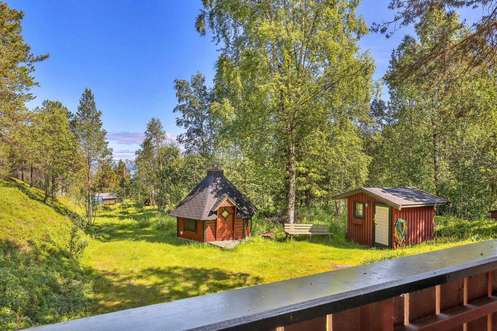 Utsikt fra verandaen over den grønne og frodige eiendommen. Galleribilde