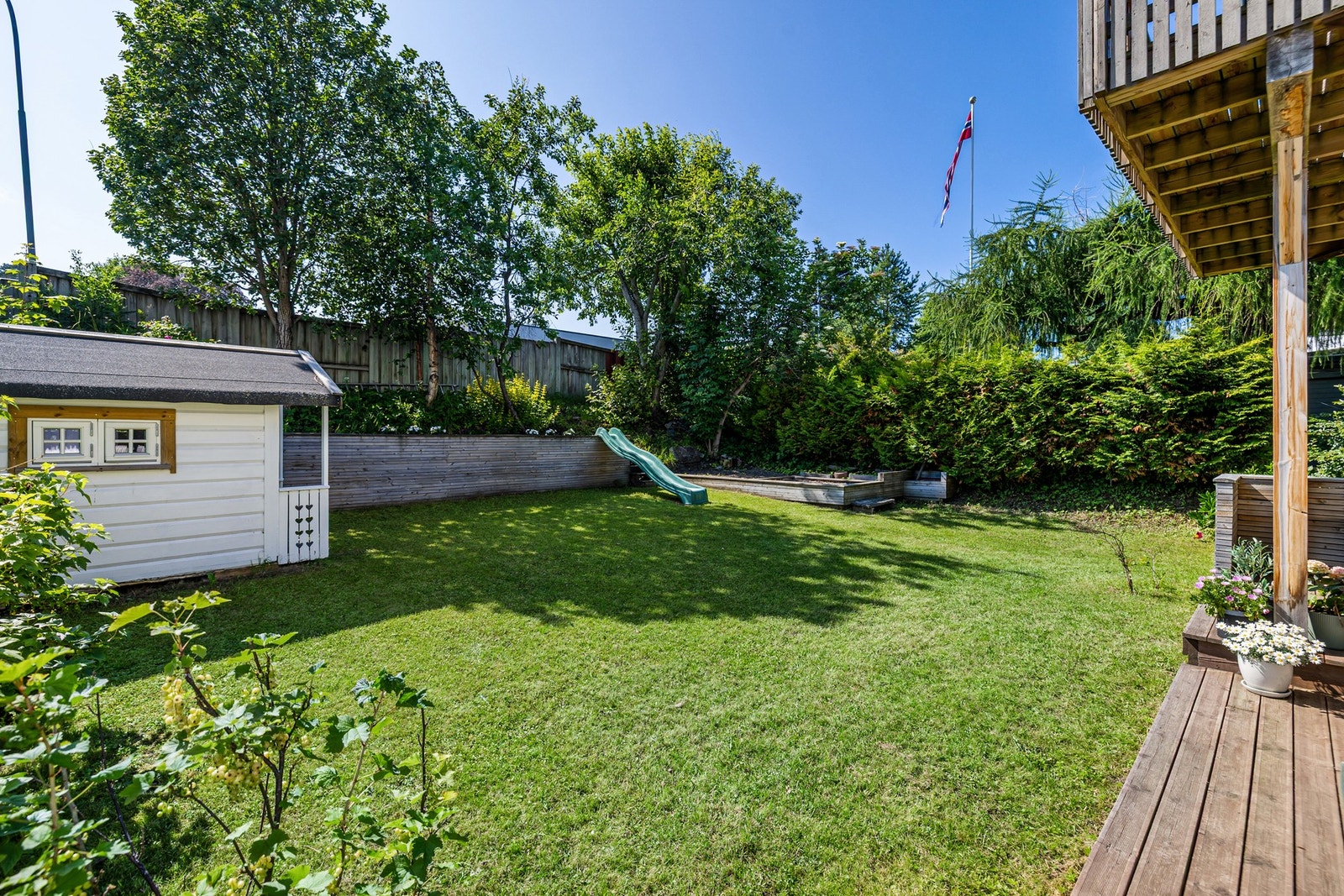Terrassen er delvis overbygd med en skjermet og stor plen. Galleribilde