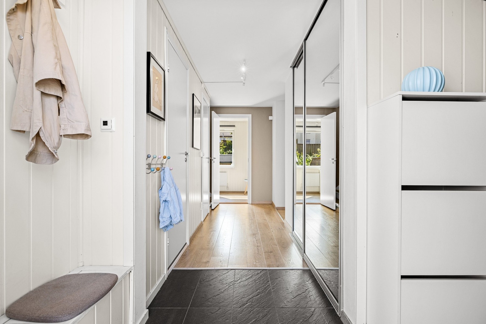 Hall/gang i 1. etasje. Innredet med skyvedørsgarderobe. 1-stavs gulv går igjen også her, og det er lagt varmekabler i entré. Galleribilde