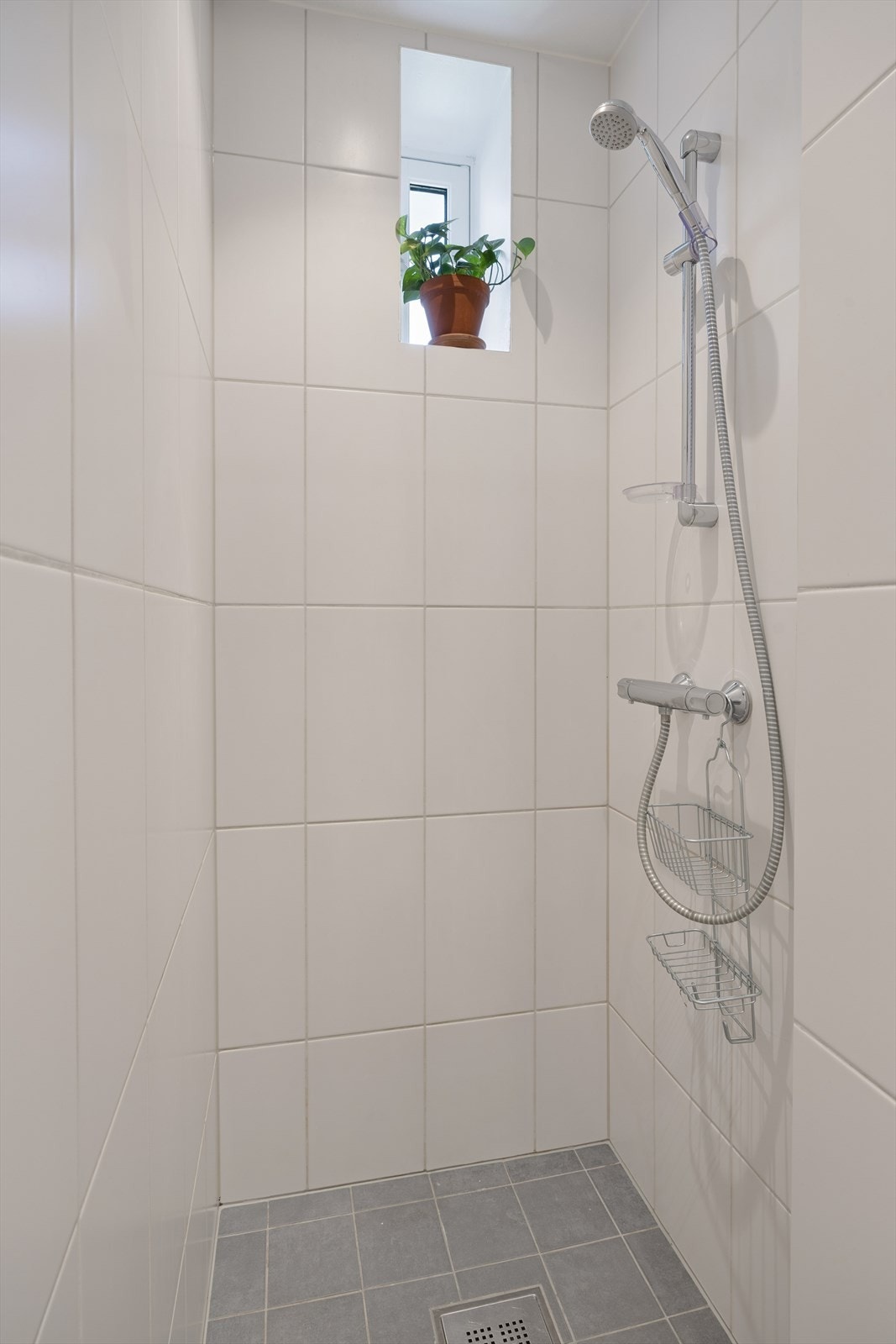 Dusjsone med nedsenket sluk og vindu som sørger for naturlig lys og lufting. En funksjonell løsning som gjør badet enkelt i daglig bruk. Galleribilde