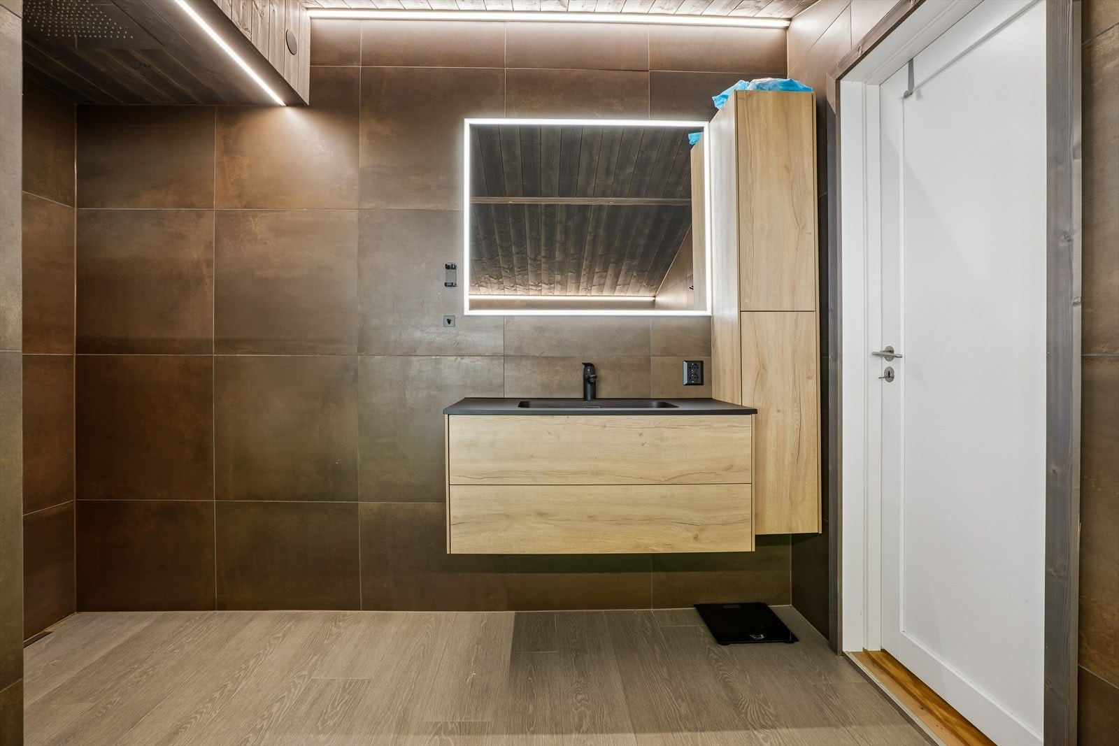 Moderne baderomsinnredning med nedfelt servant og godt med oppbevaringsplass. Galleribilde