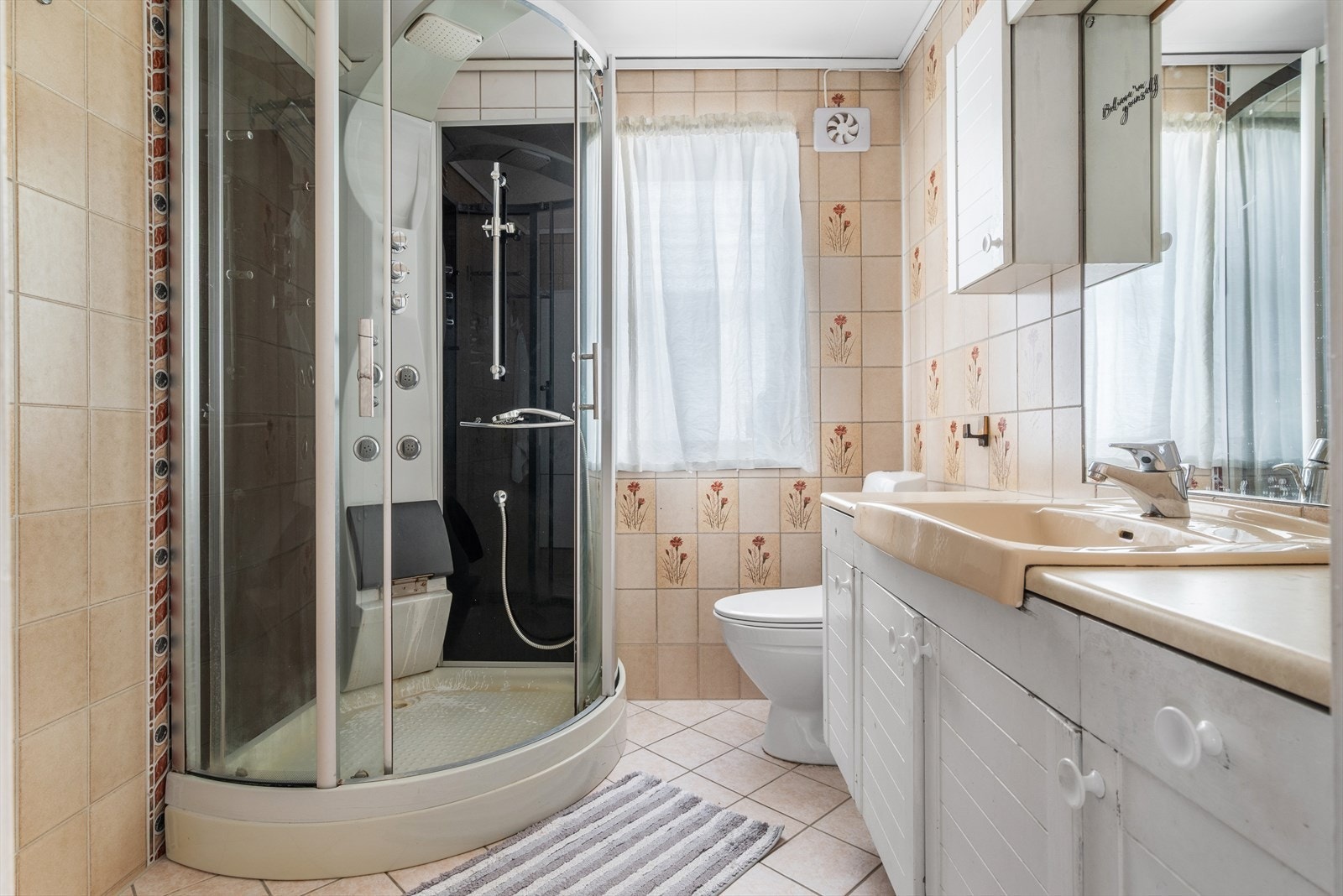 Badet er utstyrt med dusjkabinett, wc, servant og speil. Galleribilde