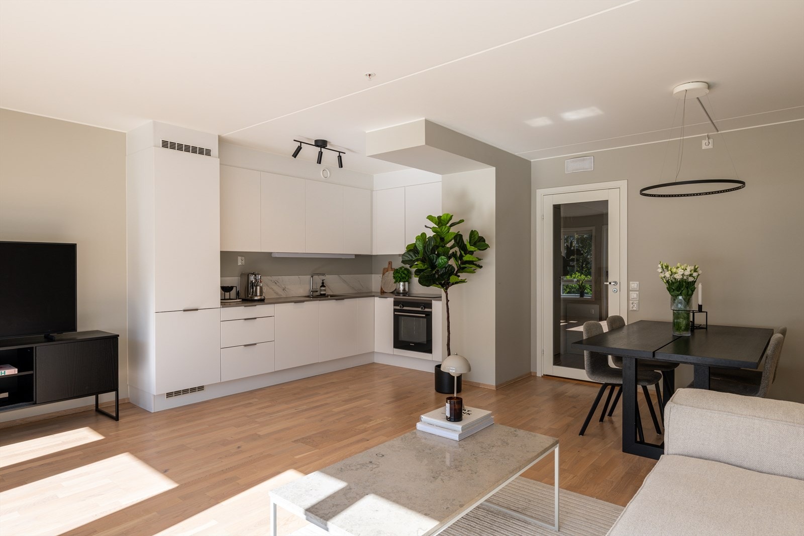Kjøkkenet er levert av Sigdal og har et tidløst design med glatte, hvite fronter og laminat benkeplate med nedfelt vask. Kjøkkenet oppgradert med steinplate som backsplash. Galleribilde