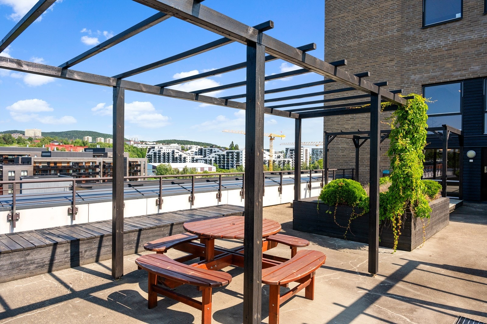 Terrassen er opparbeidet med utemøbler og pergola. Galleribilde