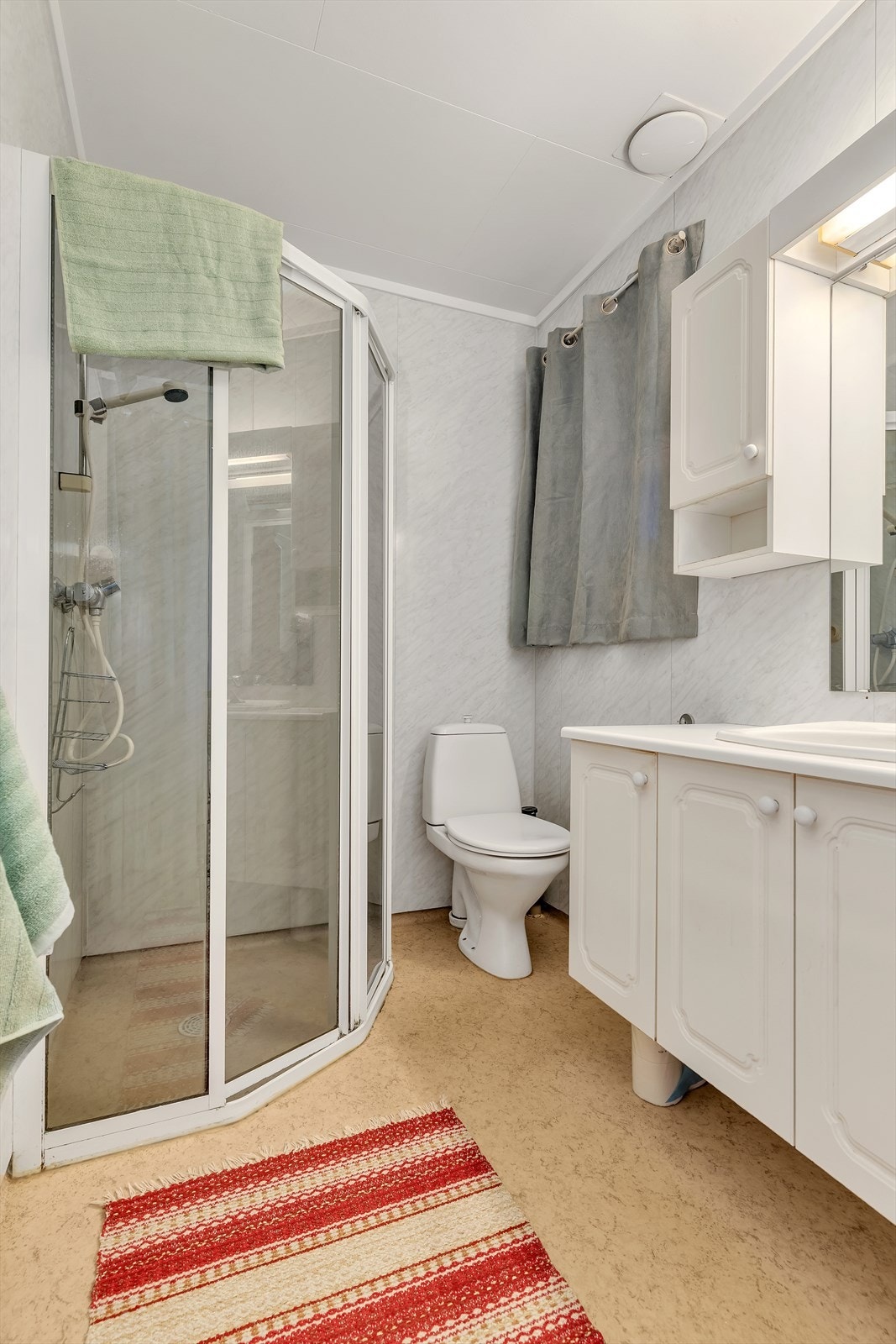 Badet i første etasje er utstyrt med dusjkabinett, servant og toalett. Galleribilde