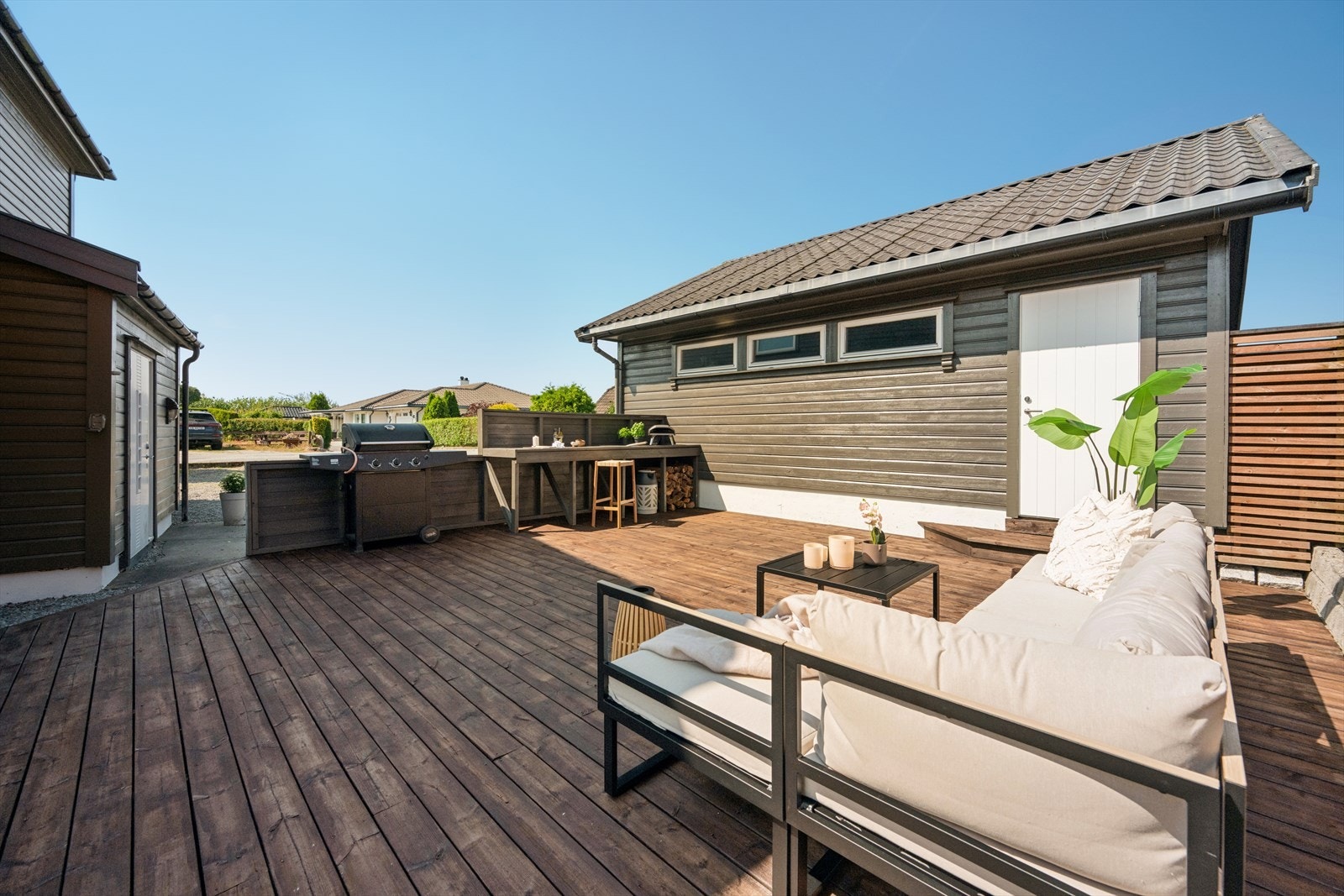 Stor terrasseplatting med plass til utekjøkken og flere sittegrupper. Galleribilde
