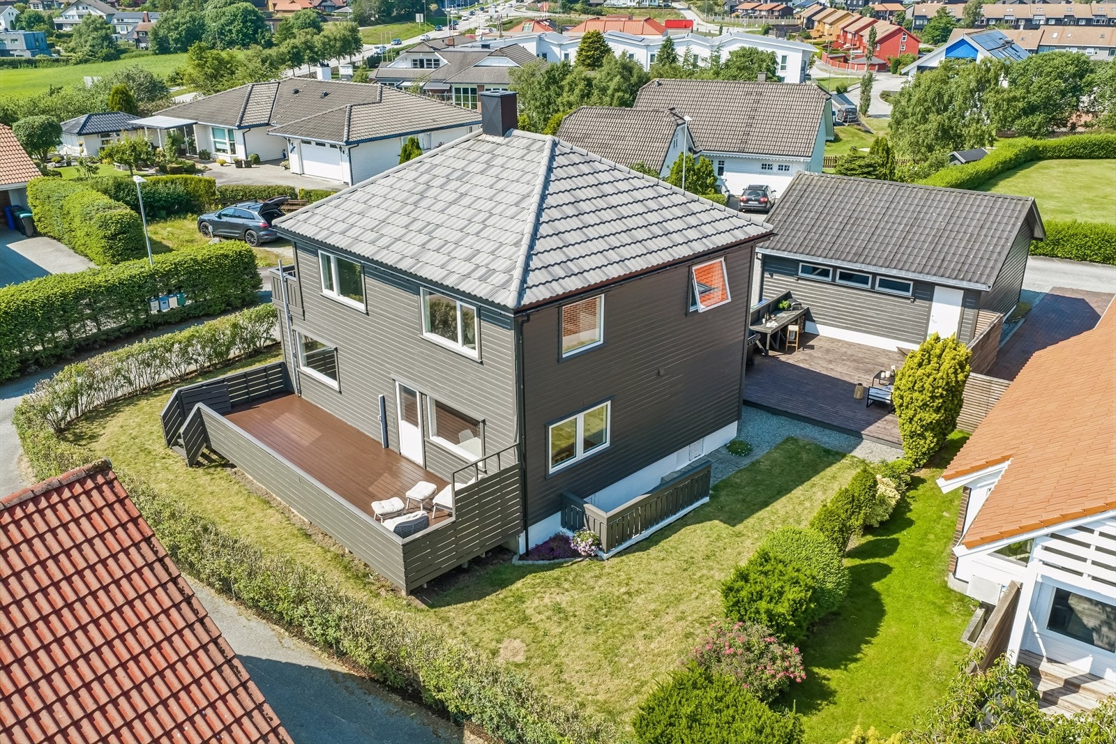 Eiendommen ligger på en relativt flat tomt med hage og flere uteplasser. Galleribilde