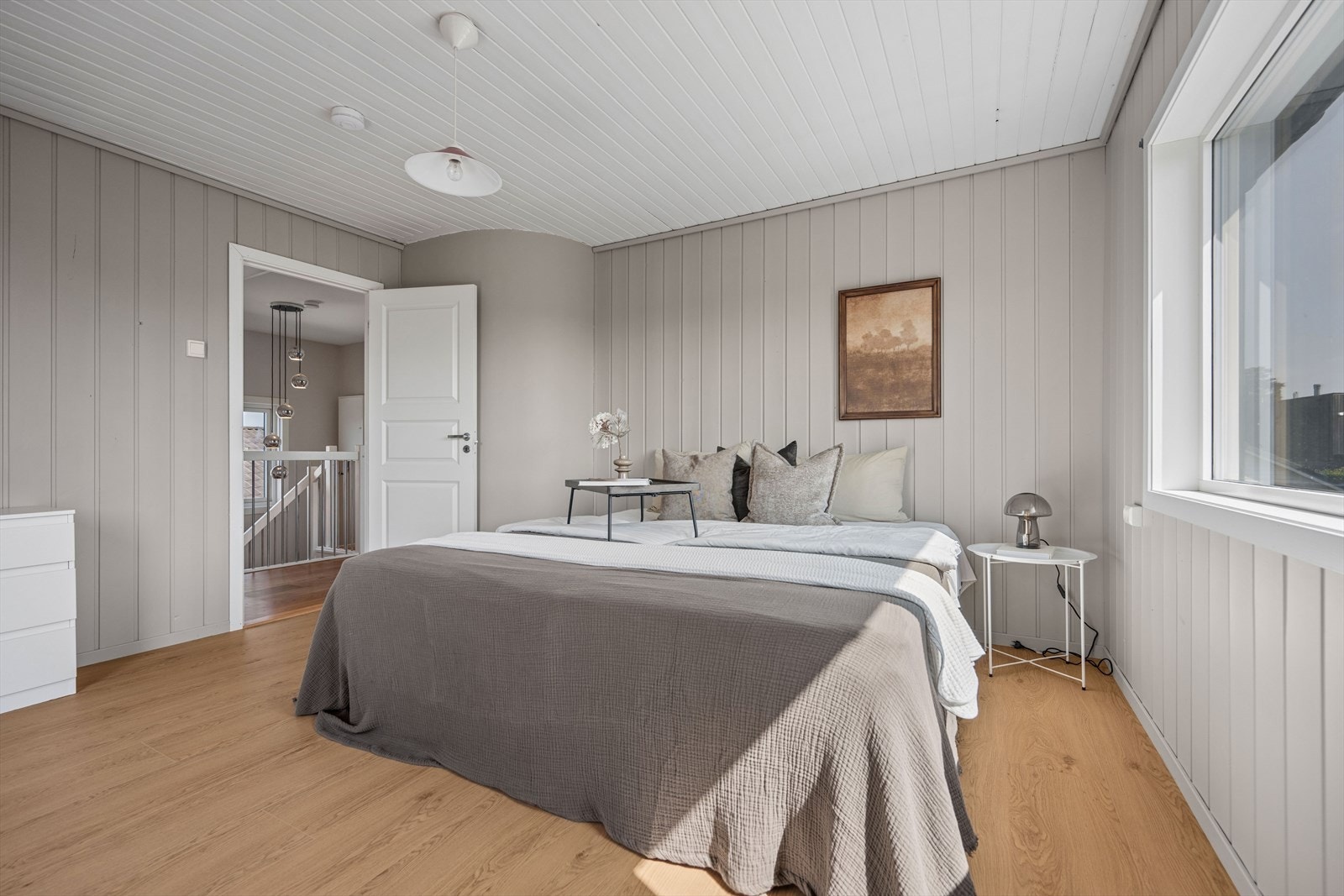 Romslig soverom med panelvegger og laminatgulv. Galleribilde