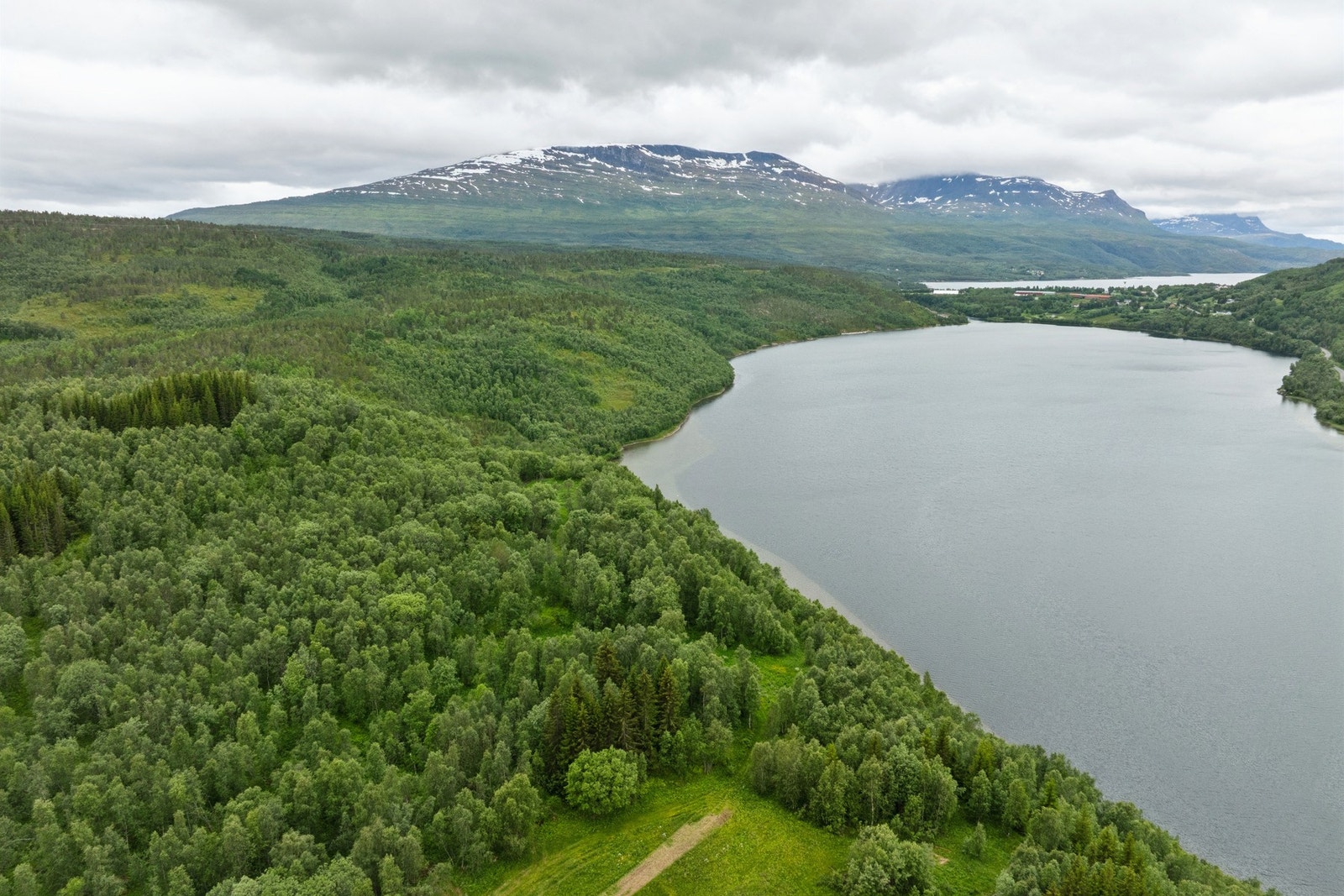 Eiendommen ligger i landlige omgivelser i Salangen kommune med utsikt over vann og natur Galleribilde