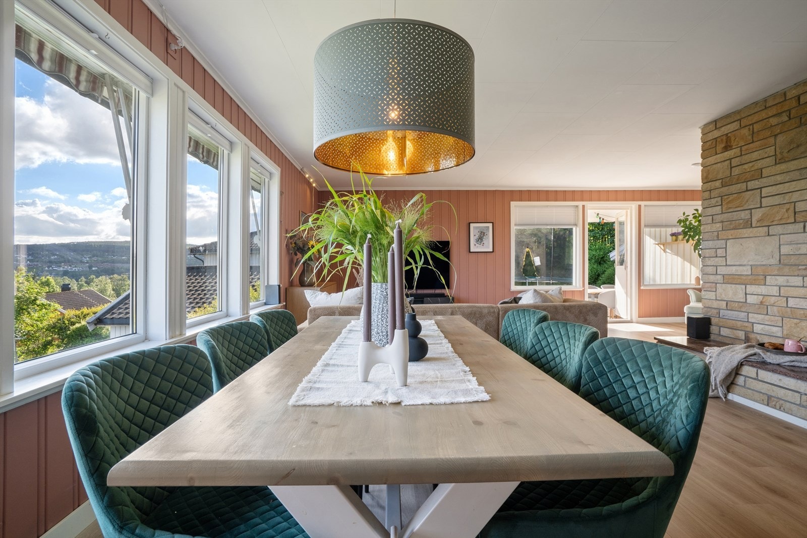 Stuen har god plass til både spisebord og sofagruppe. De store vindusflatene rammer inn utsikten. Galleribilde
