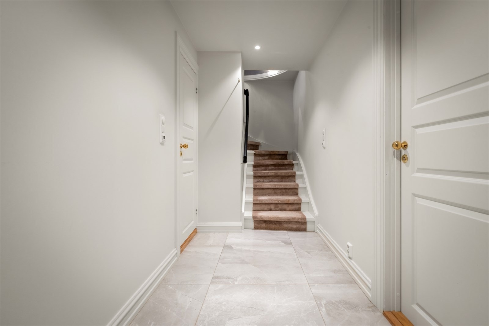 Gang i underetasjen med flislagt gulv og downlights i taket. Galleribilde