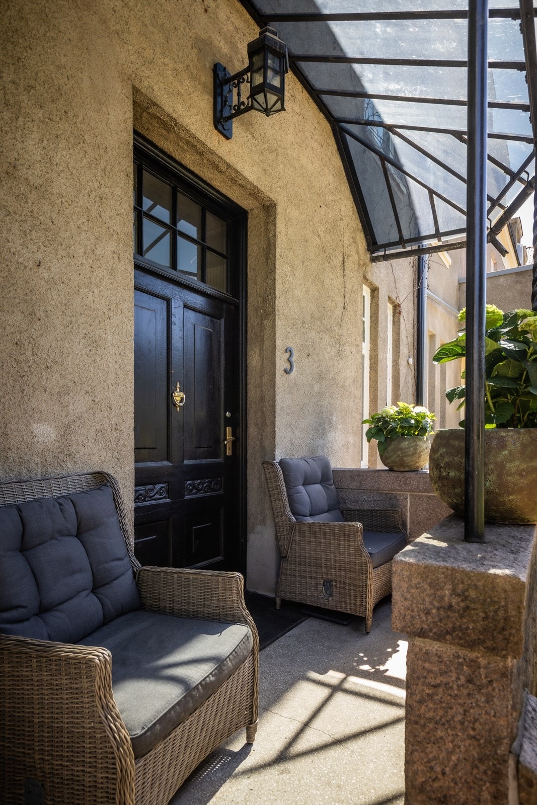 Overbygget inngangsparti med plass for en liten sittegruppe. Galleribilde