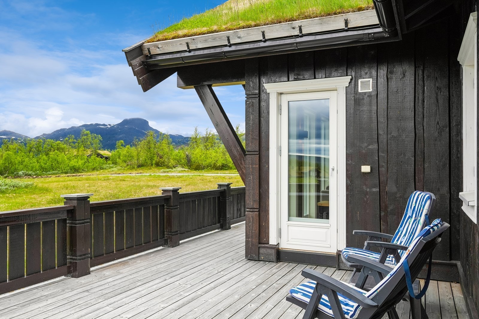 Terrassen er pent utført med solide rekkverk, skiferheller og dekorative detaljer som understreker hyttas gjennomførte uttrykk. Galleribilde