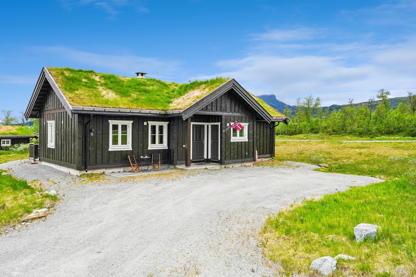 Det overbygde inngangspartiet med en vakker inngangsdør gir en lun og hyggelig ankomst til hytta. Fra inngangspartiet er det også adkomst til bod med flislagt gulv og tekniske installasjoner. Galleribilde
