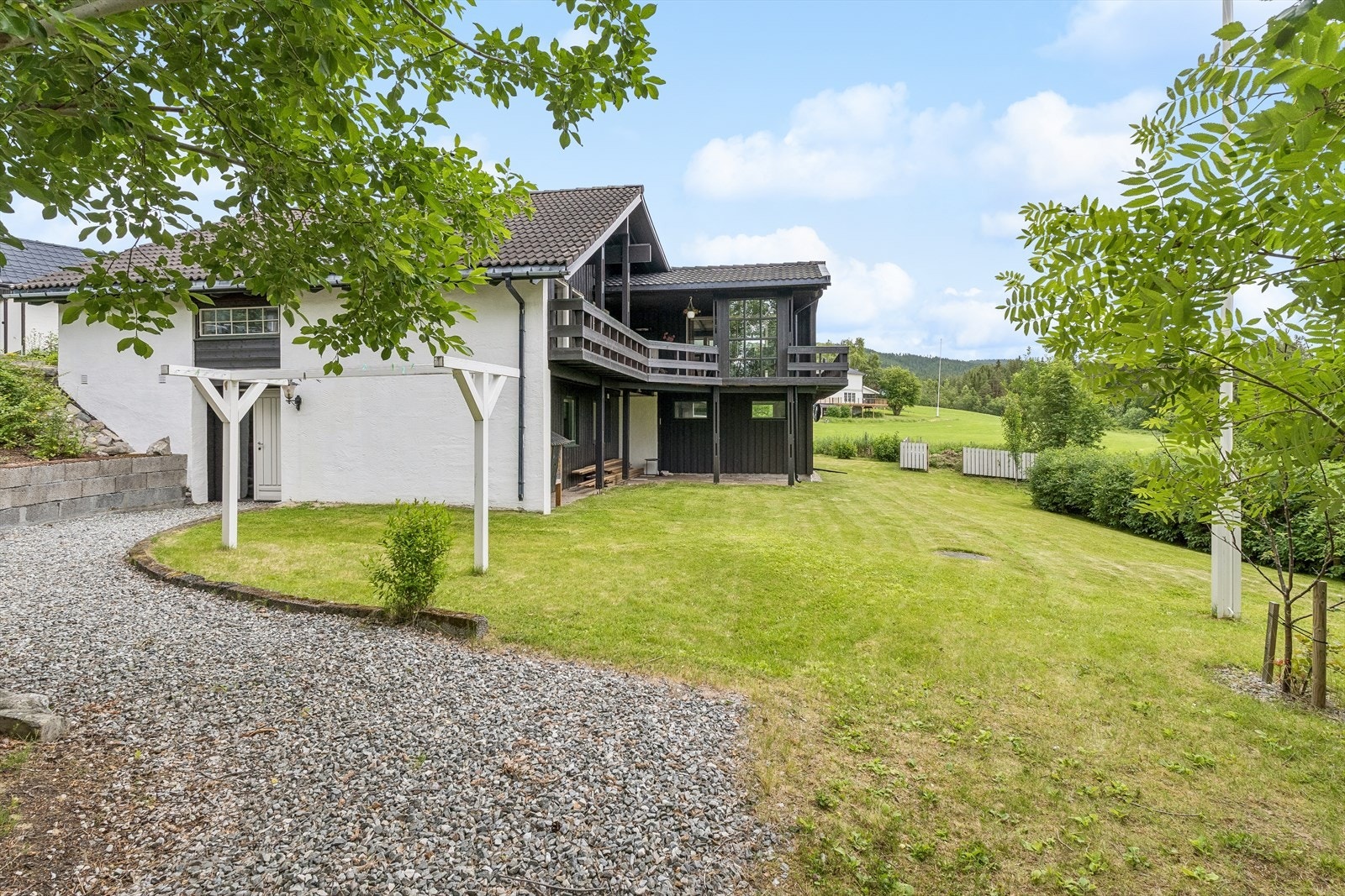Eiendommen har en stor, gruset gårdsplass og forstøtningsmur i betongstein. Galleribilde
