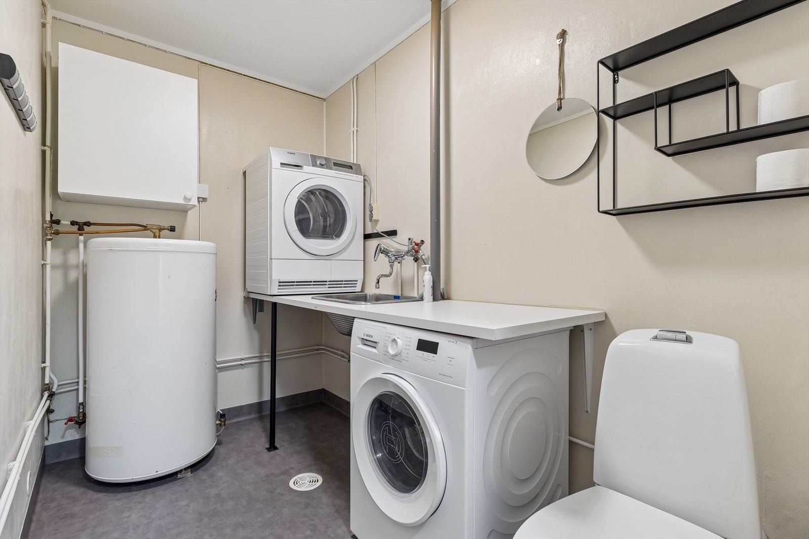 Praktisk vaskerom med toalett, opplegg for vaskemaskin og 200L varmtvannsbereder. Galleribilde