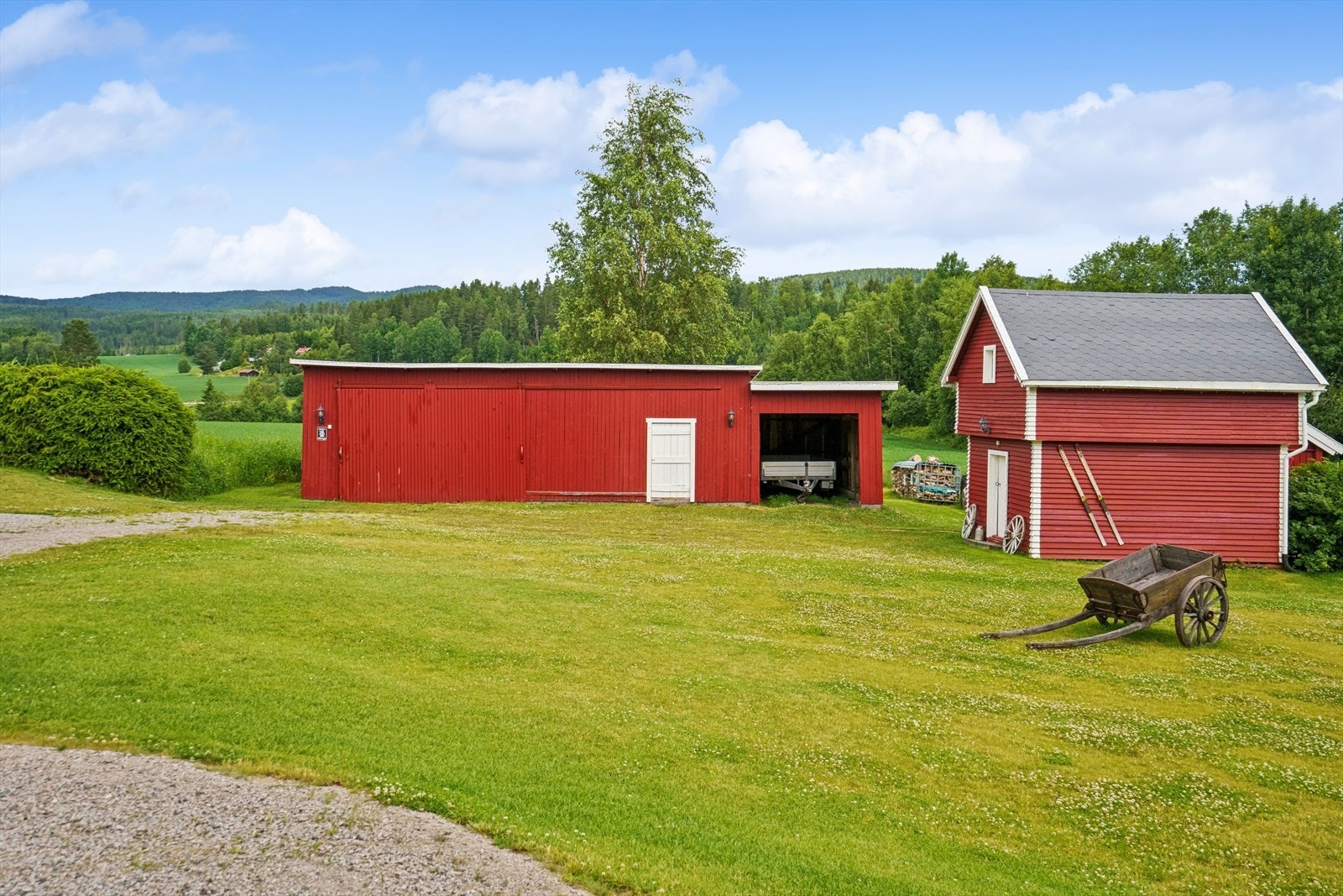 På tunet står et fjøs og en garasje med carport og vedskjul. Galleribilde