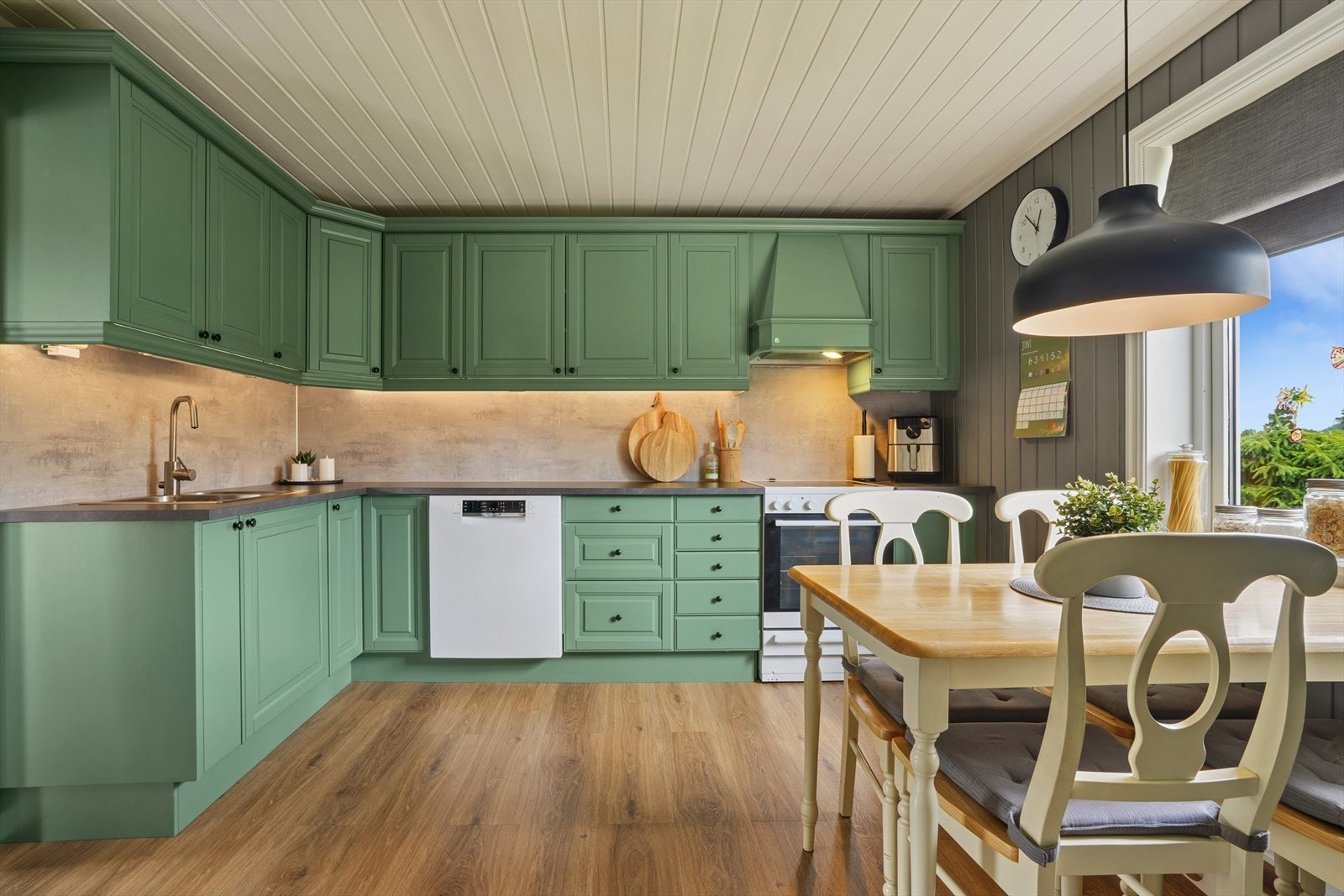 Kjøkkeninnredningen har malte fyllingsdører og Kitchen Wall mellom benk og overskap. Galleribilde