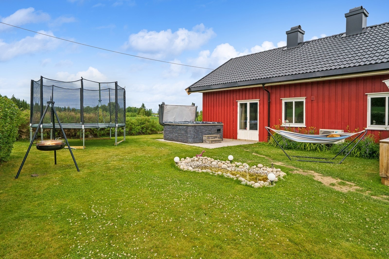 Fra plattingen kommer du rett ut i den usjenerte hagen, opparbeidet med plen og flere uteplasser. Galleribilde