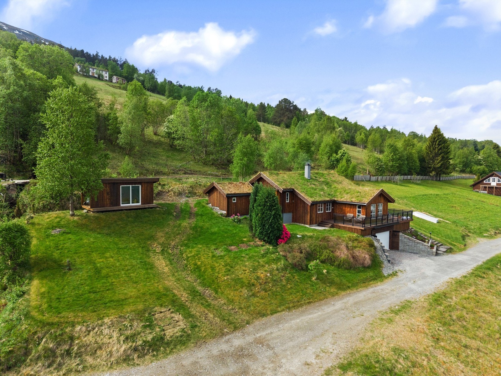 Eiendommen ligger fint til på skrånende tomt som er opparbeidet med plen, murer, treplattinger, forstøtningsmurer og natursteinstrapp. Galleribilde